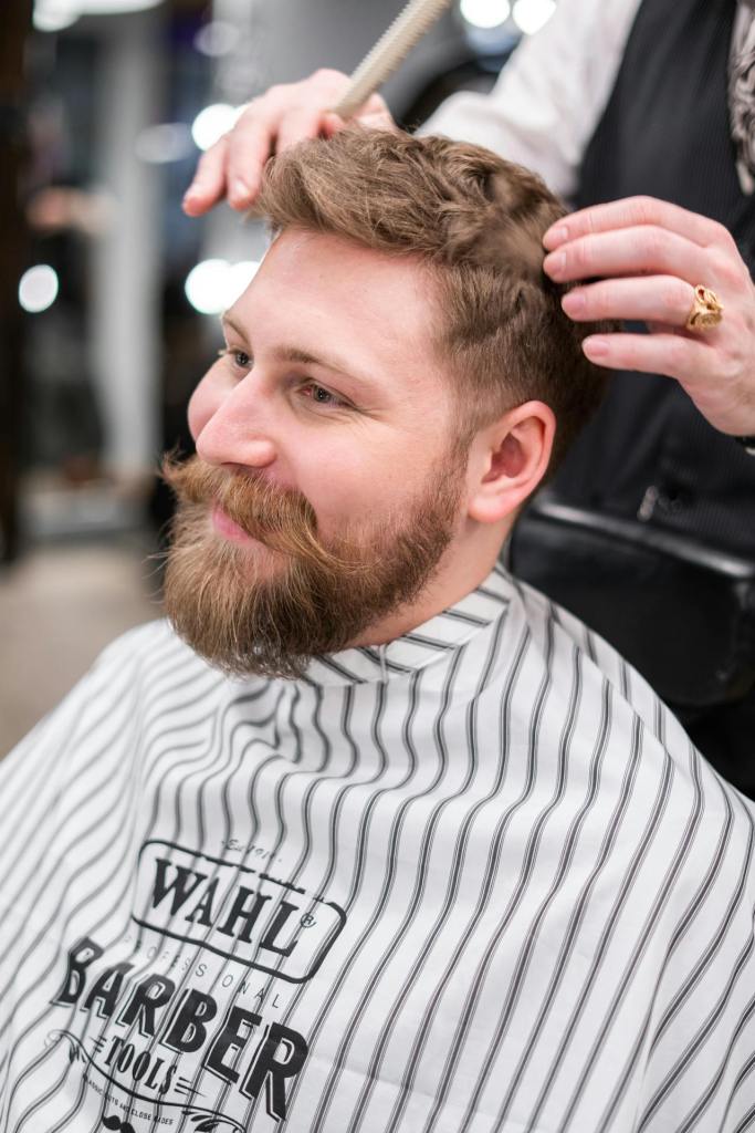 Man in White and Black Striped Veil Having a Haircut